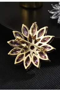 Detailed view of gold-toned flower brooch back, showing secure pin and pendant loop craftsmanship.