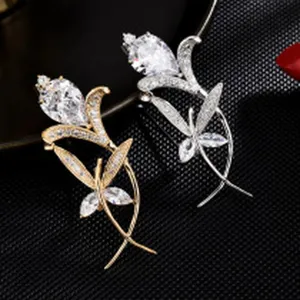Elegant crystal flower and butterfly brooch set in gold and silver, detailed shot.