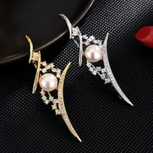 Close-up detail view of elegant pearl and crystal rhinestone brooch pin set in gold and silver.