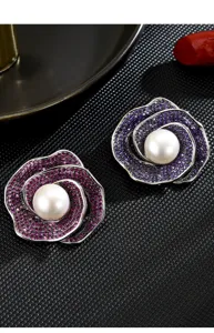 Detailed shot of elegant camellia flower brooches with sparkling purple stones and pearls.
