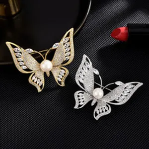Detailed shot of elegant butterfly brooches with sparkling crystals and central pearl accent.