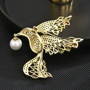 Exquisite gold bird brooch with dangling pearl and colorful stones for women luxury fashion accessory.