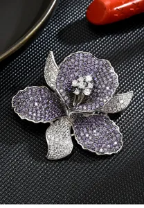 Close-up detail of the elegant purple and white zircon orchid brooch, sparkling crystal floral design.
