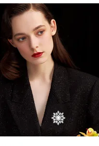 Exquisite snowflake brooch detail featuring sparkling zirconia and natural freshwater pearl.