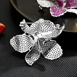 Elegant silver orchid brooch with sparkling zirconia stones, perfect for jackets and gowns.
