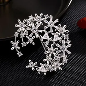 Exquisite silver-tone crystal brooch detail, sparkling cubic zirconia floral cluster design.