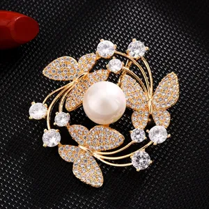 Detailed close-up view of the sparkling zircon butterfly brooch with a lustrous central pearl.