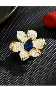 Elegant flower magnetic brooch with sparkling rhinestones and blue center stone for anti-glare.