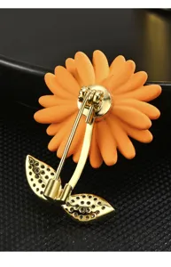 Detail view of a cute enamel sunflower brooch with crystal leaves and gold-tone pin back.