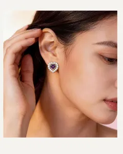 Elegant heart-shaped cluster earrings with purple center stone and sparkling stones.