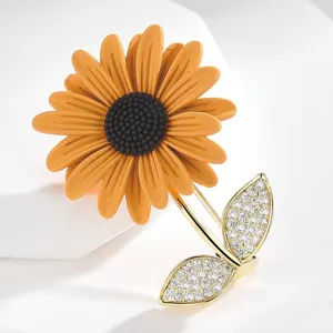 Elegant sunflower enamel brooch with sparkling cubic zirconia leaves and shiny gold stem main view