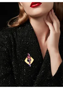 Primer plano detallado de broche cristal geométrico piedras rosa morado en chaqueta tweed.