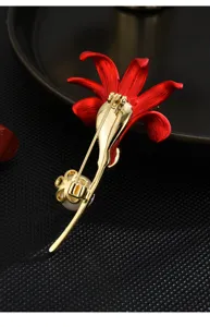 Detailed view of the gold-plated red enamel lily flower brooch back with pearl accent.