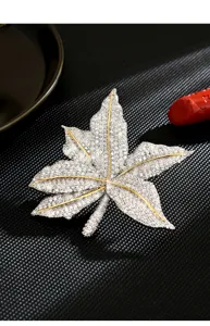 Detailaufnahme einer funkelnden Strass Ahornblatt Brosche mit klarem Kristall Pavé Design.
