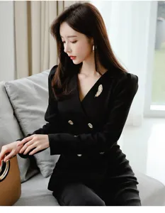 Exquisite golden feather brooch detail on elegant black blazer, stylish fashion accessory.