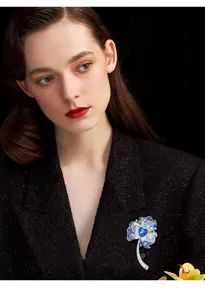 Detailed view of exquisite blue flower brooch with crystal rhinestones and dark heart stone.