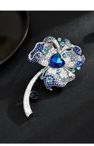 Exquisite blue rhinestone flower brooch detail, elegant silver tone crystal corsage accessory.