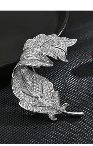 Stunning silver leaf brooch with pave crystals, intricate details, elegant suit accessory.