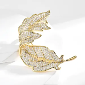 Elegant gold-tone crystal leaf brooch pin, luxurious rhinestone suit accessory for women.