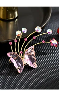 Exquisite crystal butterfly brooch close-up, elegant pink zircon floral metallic pin.