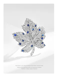 Elegant blue zircon maple leaf brooch featuring sparkling crystals and polished silver-tone metal.