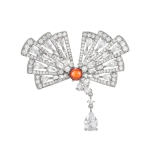 Elegante spilla a ventaglio con zirconi scintillanti e una pietra centrale rossa d'impatto.