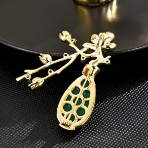 Gold-plated plum blossom vase brooch featuring elegant green chalcedony stones main view
