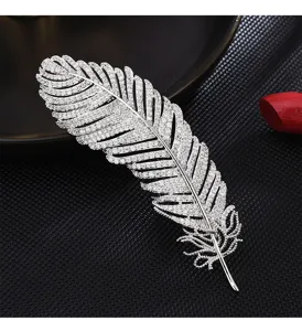 Exquisite silver feather brooch pin embellished with sparkling rhinestones for women fashion outfits.