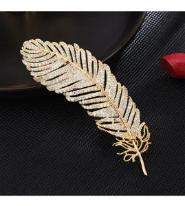 Closeup view of a luxury gold rhinestone feather brooch, sparkling crystal details for apparel.