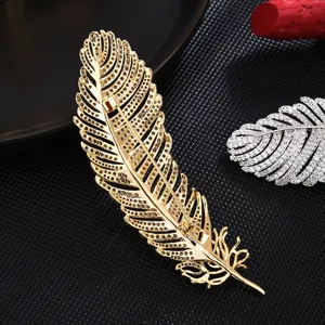 Luxury gold feather brooch with sparkling crystal rhinestones, elegant suit pin accessory for women.