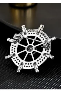 Detailed close-up of silver ship wheel brooch back pin, featuring micro-inlaid cubic zirconia.