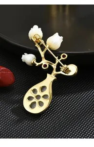 Close-up view of the vintage gold-plated vase brooch back structure, showing secure pin and clasp.