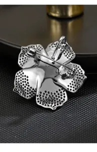 Exquisite flower brooch back detail view, elegant metal craft and secure pin design for women.