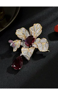 Close-up view of the luxury floral brooch with sparkling crystals and deep red gemstones.