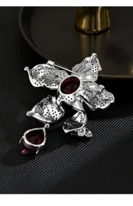 Exquisite silver-tone ruby flower brooch detail showing fine back craftsmanship and secure pin.