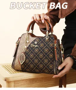Sac seau bicolore tendance avec pendentif feuille, sac à main élégant et bandoulière pour femme.