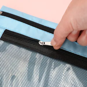 Gros plan détaillé de la trousse en filet bleu montrant une fermeture éclair en métal solide.
