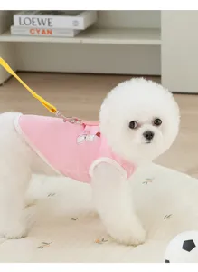 Detail shot of pink mesh pet harness vest worn by a white dog, breathable fabric, cute cat print.