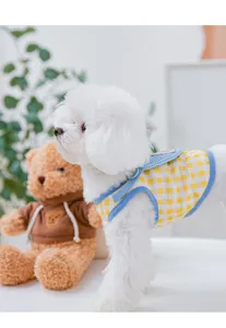 Dettaglio gilet per cani con motivo a quadri gialli e bordo blu per abbigliamento estivo.