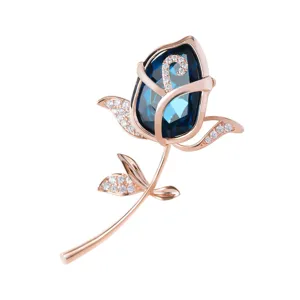 Elegant blue crystal rose brooch featuring sparkling rhinestones in a polished rose gold tone finish.