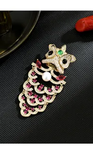 Exquisite gold Chinese lion dance brooch detail, featuring sparkling rhinestones and pearl.