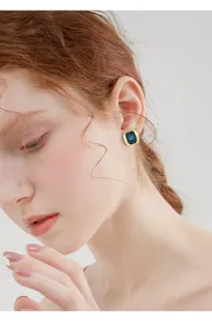 Primer plano detallado de pendientes geométricos cuadrados de cristal, estilo elegante.