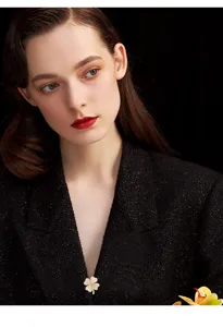 Close-up detail of the elegant cat-eye four-leaf clover brooch pin showcasing fine craftsmanship.