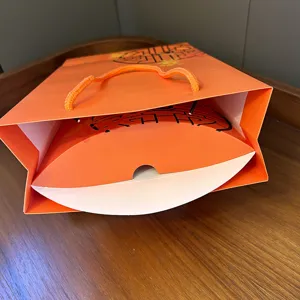 Orange paper gift bag and pillow box detail view, elegant packaging for scarves and gifts.