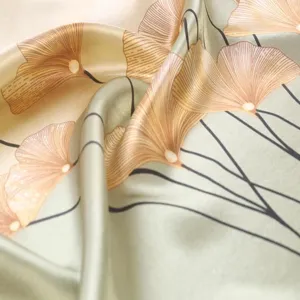 Detailed view of the elegant satin silk square scarf with a chic ginkgo leaf print design.