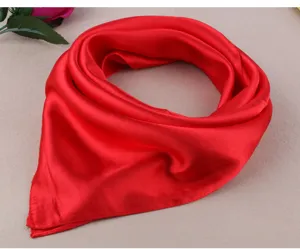 Close-up view of a smooth red satin square scarf, showing fine texture and glossy fabric detail.
