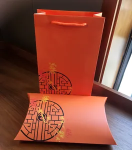 Orange gift bag pillow box set with Chinese window pattern for holiday scarf packaging.