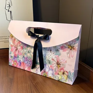 Pink envelope gift box with floral watercolor pattern and black ribbon bow for luxury scarf packaging.