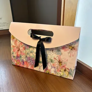 Envelope gift box with floral print and black ribbon bow, ideal for scarves and shawls packaging.