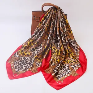 Detailed view of luxury leopard print square silk scarf with red border and belt tassel design.